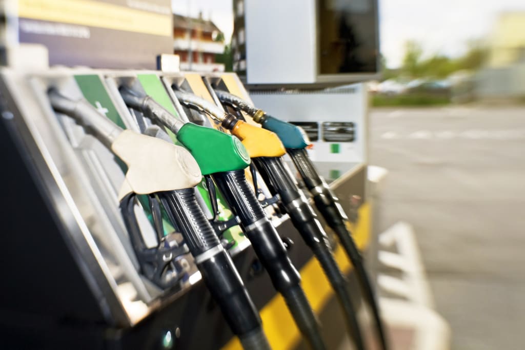 Close-up of fuel pump nozzles at a petrol station, showing different fuel types for vehicles